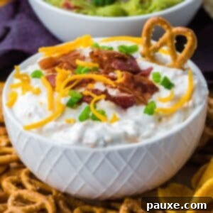 Deconstructed Baked Potato Dip 9 A bowl of loaded baked potato dip topped with shredded cheese, bacon, and green onion.