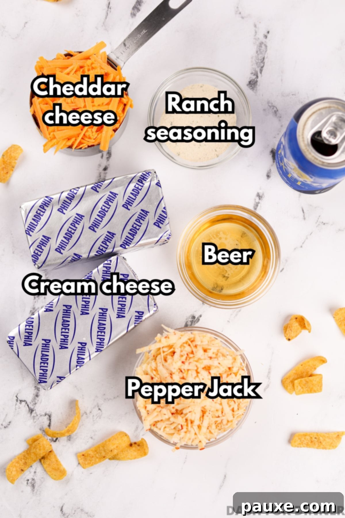Ultimate Beer Cheese Dip 3 All five ingredients laid out: blocks of cream cheese, a bottle of beer, a packet of ranch seasoning, a block of pepper jack cheese, and a block of cheddar cheese.
