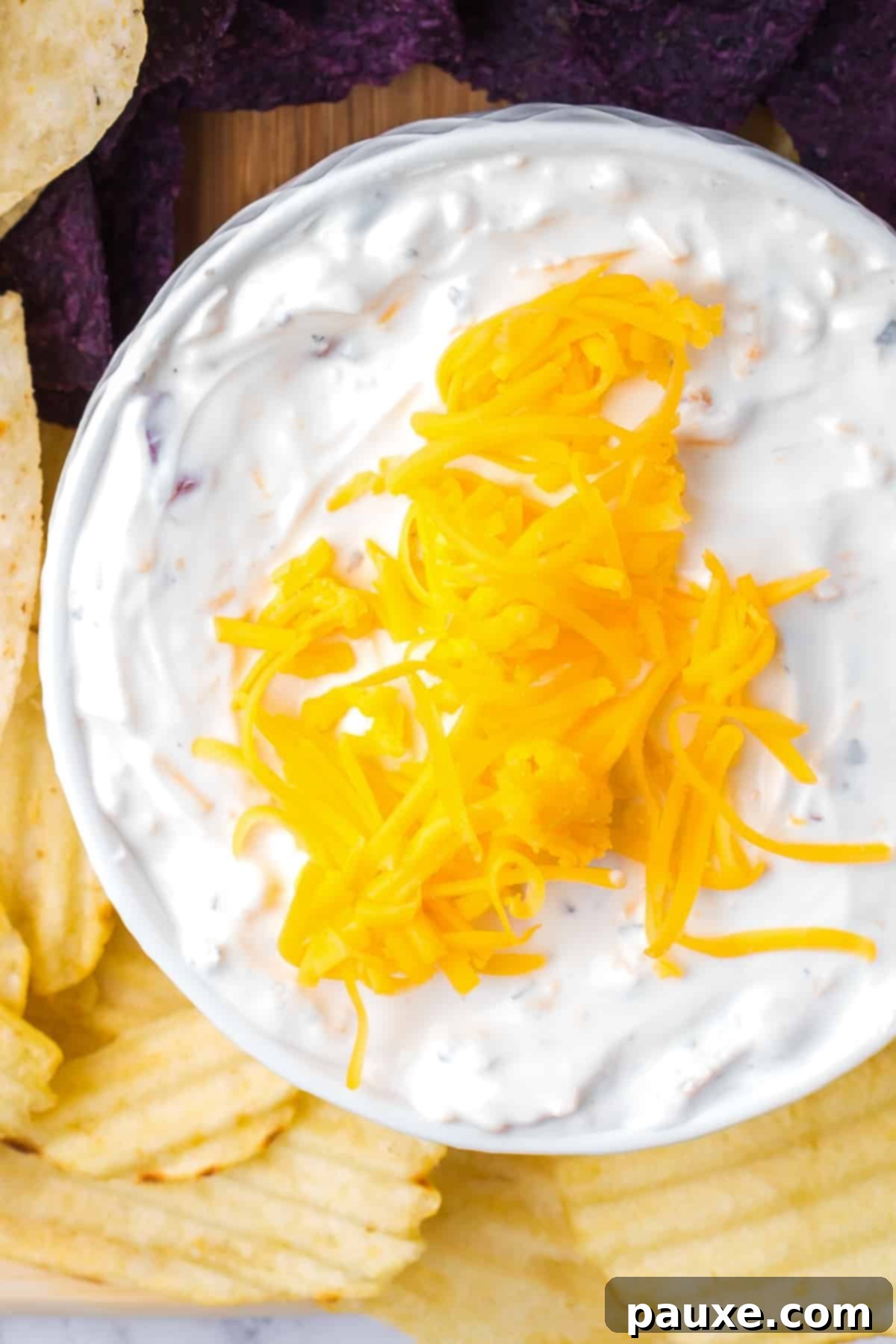 Ultimate Beer Cheese Dip 6 A bowl of creamy beer dip, freshly made, topped with a sprinkle of extra shredded cheddar cheese, ready to be chilled.