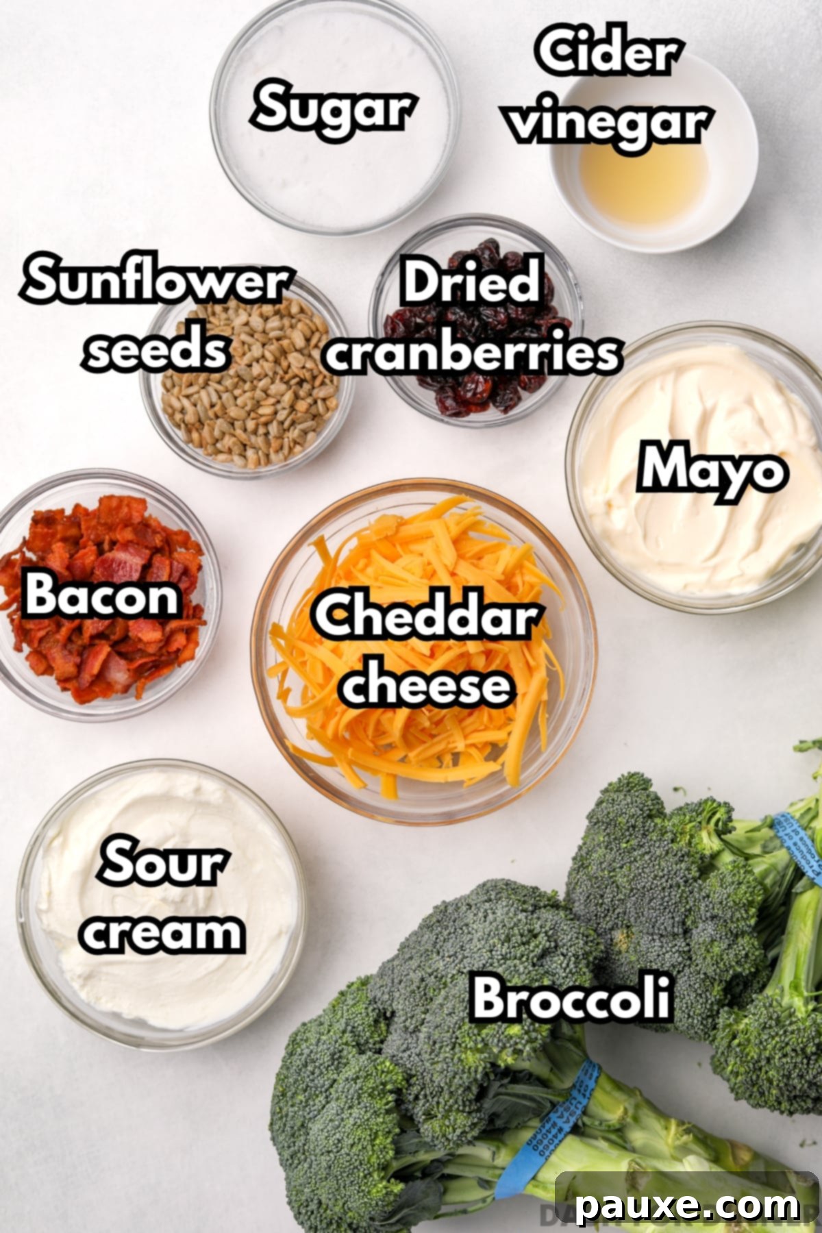 Creamy Crunch Broccoli Salad 3 The array of fresh ingredients required to make delicious broccoli salad, including vibrant green broccoli, sharp cheddar cheese, crispy bacon, creamy sour cream, and mayonnaise.