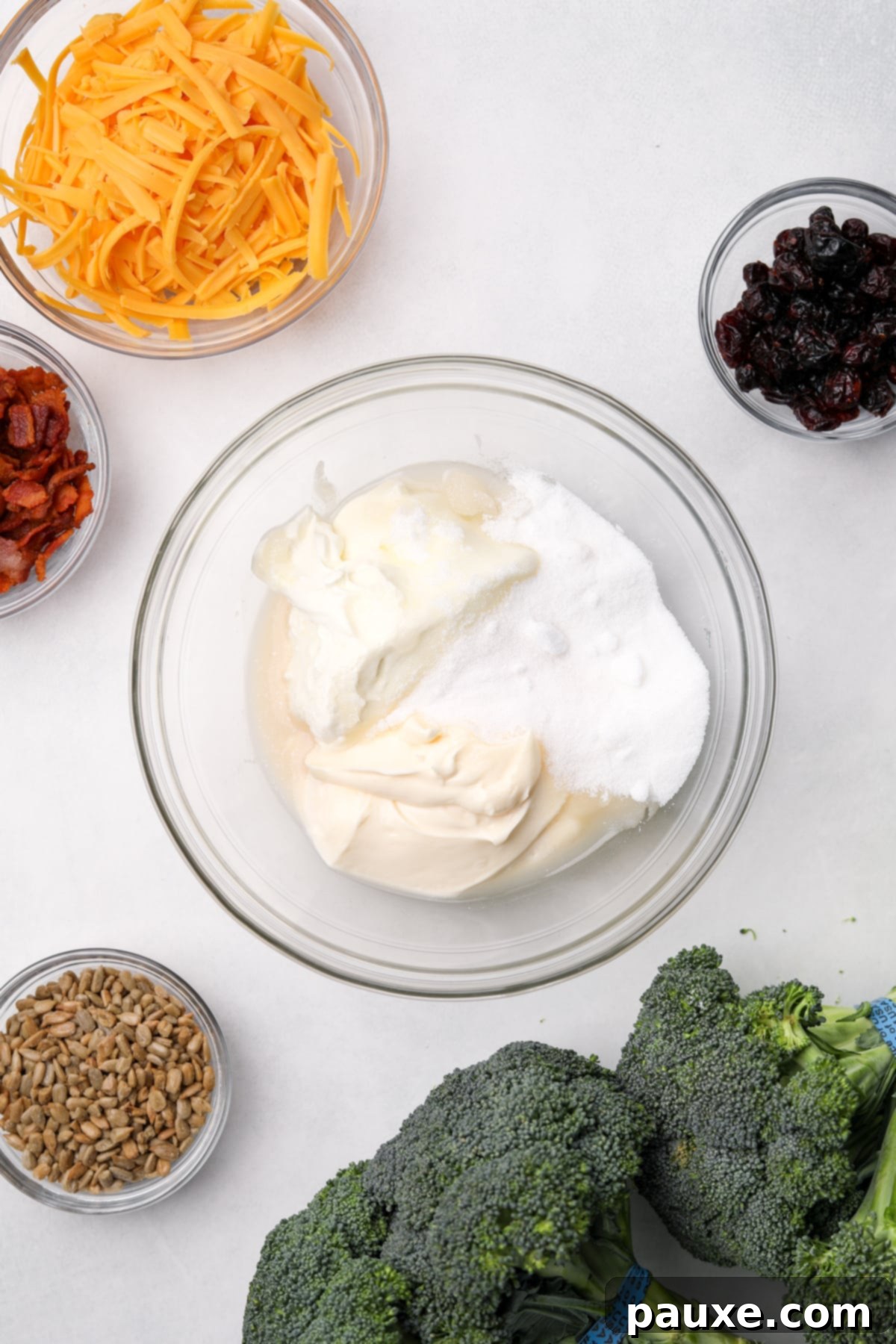 Creamy Crunch Broccoli Salad 4 A medium bowl containing mayonnaise, sour cream, and sugar, waiting to be mixed for the creamy dressing.
