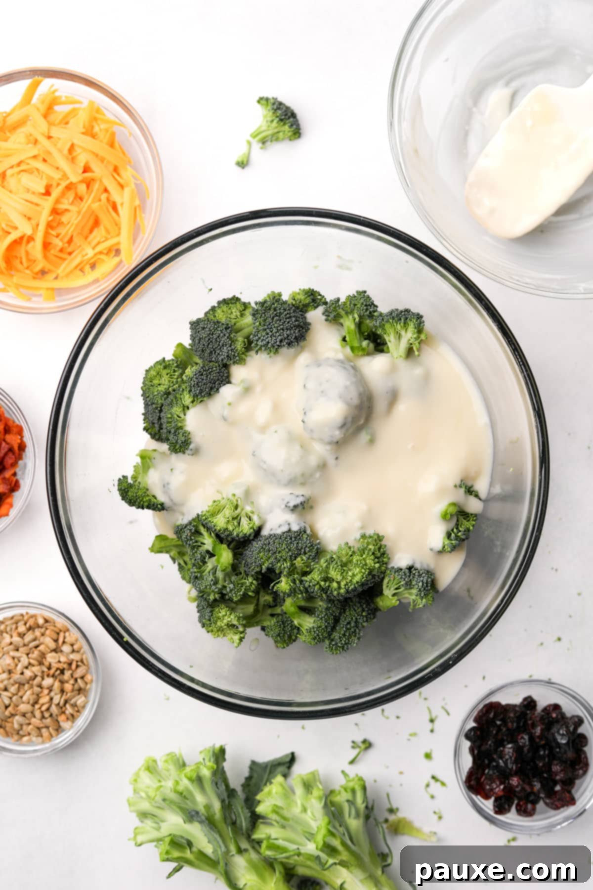 Creamy Crunch Broccoli Salad 7 Pouring the creamy homemade dressing directly over the fresh broccoli florets in a large bowl.