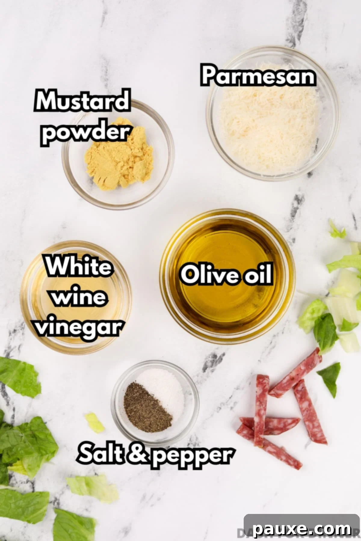 Leon's Signature Dressing 3 Six key ingredients laid out on a table: a bottle of olive oil, a bottle of white wine vinegar, a container of mustard powder, a block of Parmesan cheese, salt, and black pepper, all essential for the Leon Salad Dressing.