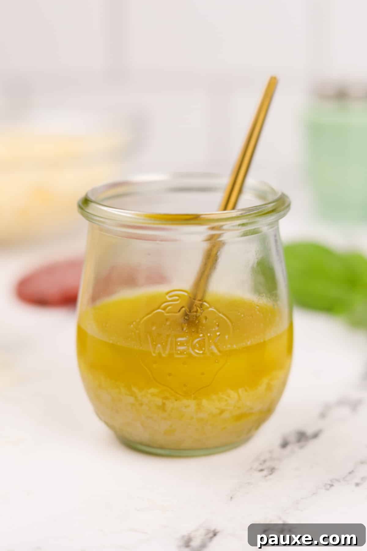 Leon's Signature Dressing 7 A small glass jar of homemade Leon Salad Dressing with a tiny gold serving spoon inside, indicating its readiness for use.