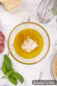 A small bowl with parmesan cheese, olive oil, and wine vinegar.