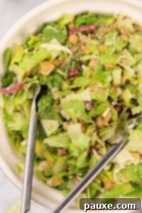 Tossing a chopped salad with tongs.