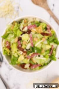 A large bowl of chopped Italian Salad with sliced salami and mozzarella.
