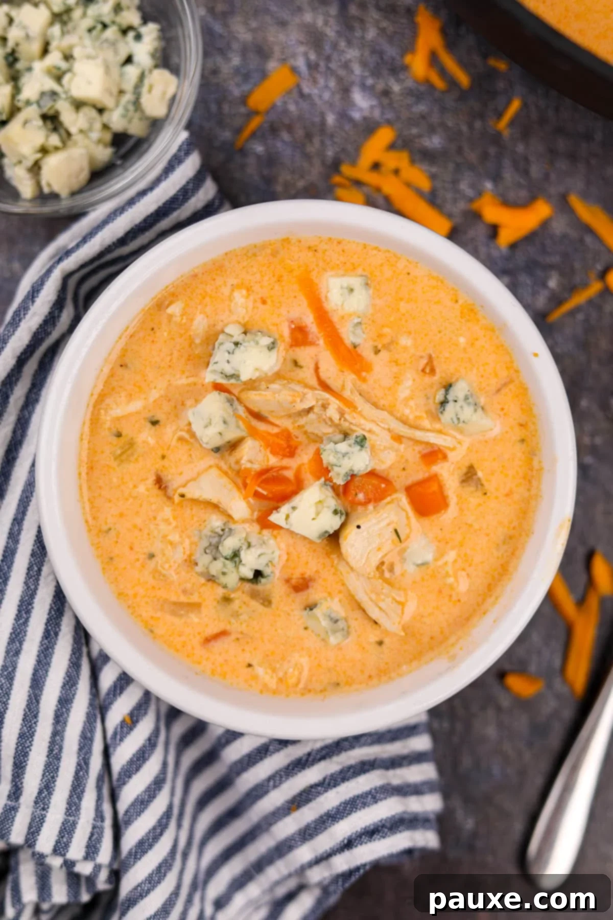 Spicy Buffalo Chicken Chowder 2 A bowl of creamy buffalo chicken soup topped with crumbled blue cheese and fresh herbs, ready to be enjoyed.