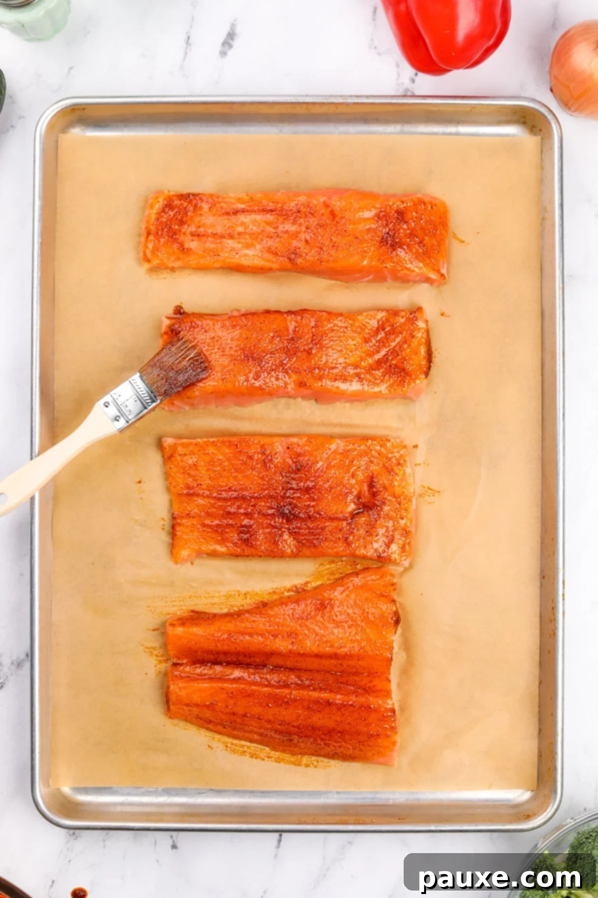 Brushing salmon fillets with a seasoned oil.