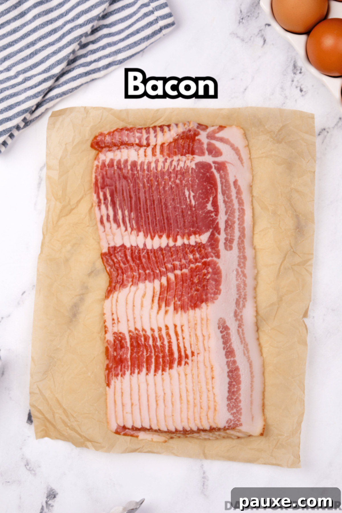Perfectly Crispy Oven Bacon 3 Multiple slices of uncooked bacon on a piece of parchment paper, laid out on a marble counter, ready for baking.