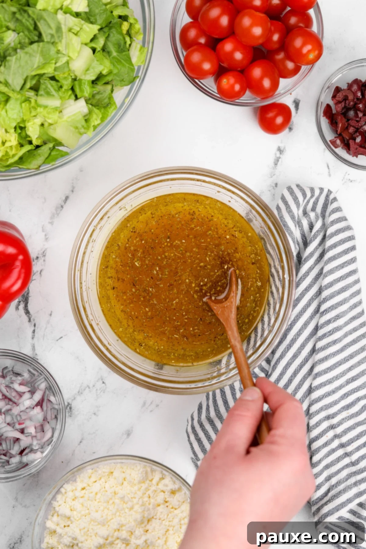 Zesty Mediterranean Vinaigrette 5 A whisk vigorously mixing the ingredients for Greek salad dressing in a small bowl, showing the emulsification process.