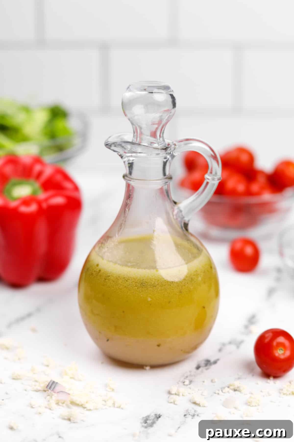 Zesty Mediterranean Vinaigrette 6 A salad dressing cruet, half-filled with the light gold homemade olive oil based Greek dressing, ready to be used.