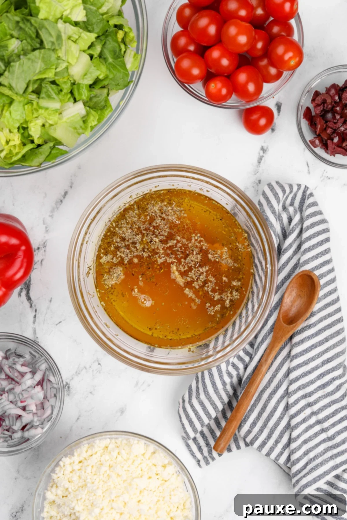 Vibrant Greek Chopped Salad 4 Various ingredients for salad dressing including olive oil, red wine vinegar, lemon, and spices in small bowls.