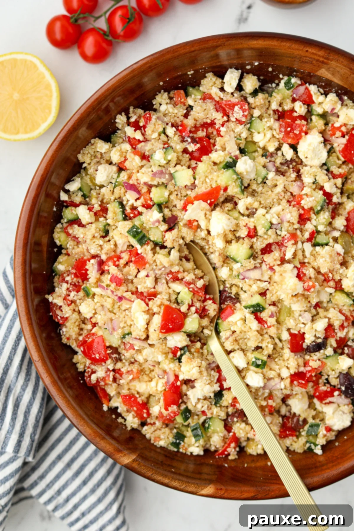 Zesty Mediterranean Quinoa Salad 5 A rustic wooden bowl filled to the brim with a fresh and colorful Greek Quinoa Salad, ready to be served.