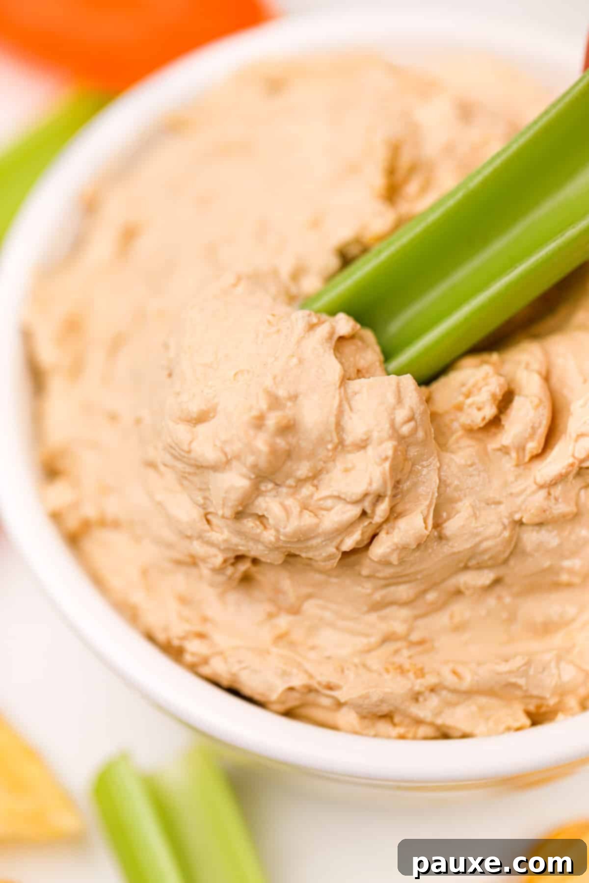 Golden State Creamy Dip 9 A crisp celery stick being dipped into a creamy bowl of homemade French Onion Dip, highlighting a healthy and refreshing dipper option. The dip clings perfectly to the celery.