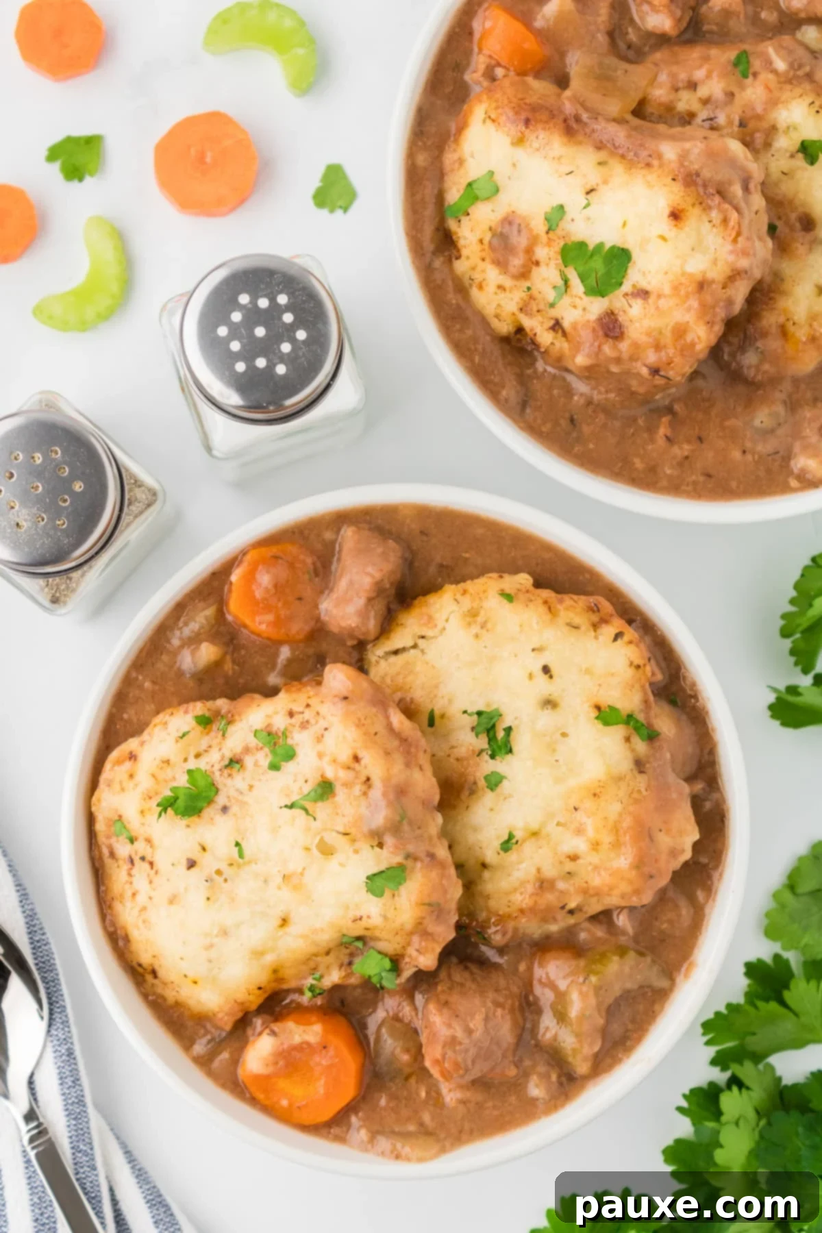 Comforting Slow Cooker Beef Stew and Dumplings 2 A bowl of beef stew topped with two dumplings, garnished with parsley. The stew is rich with tender beef and chunky vegetables.