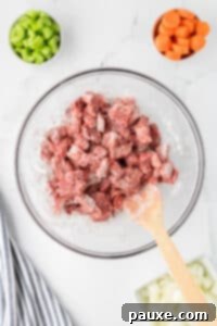 Comforting Slow Cooker Beef Stew and Dumplings 18 Beef stew meat being coated with flour.