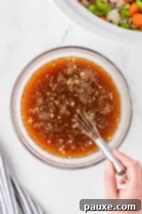 Comforting Slow Cooker Beef Stew and Dumplings 20 Whisking together beef broth, seasonings, and other ingredients.