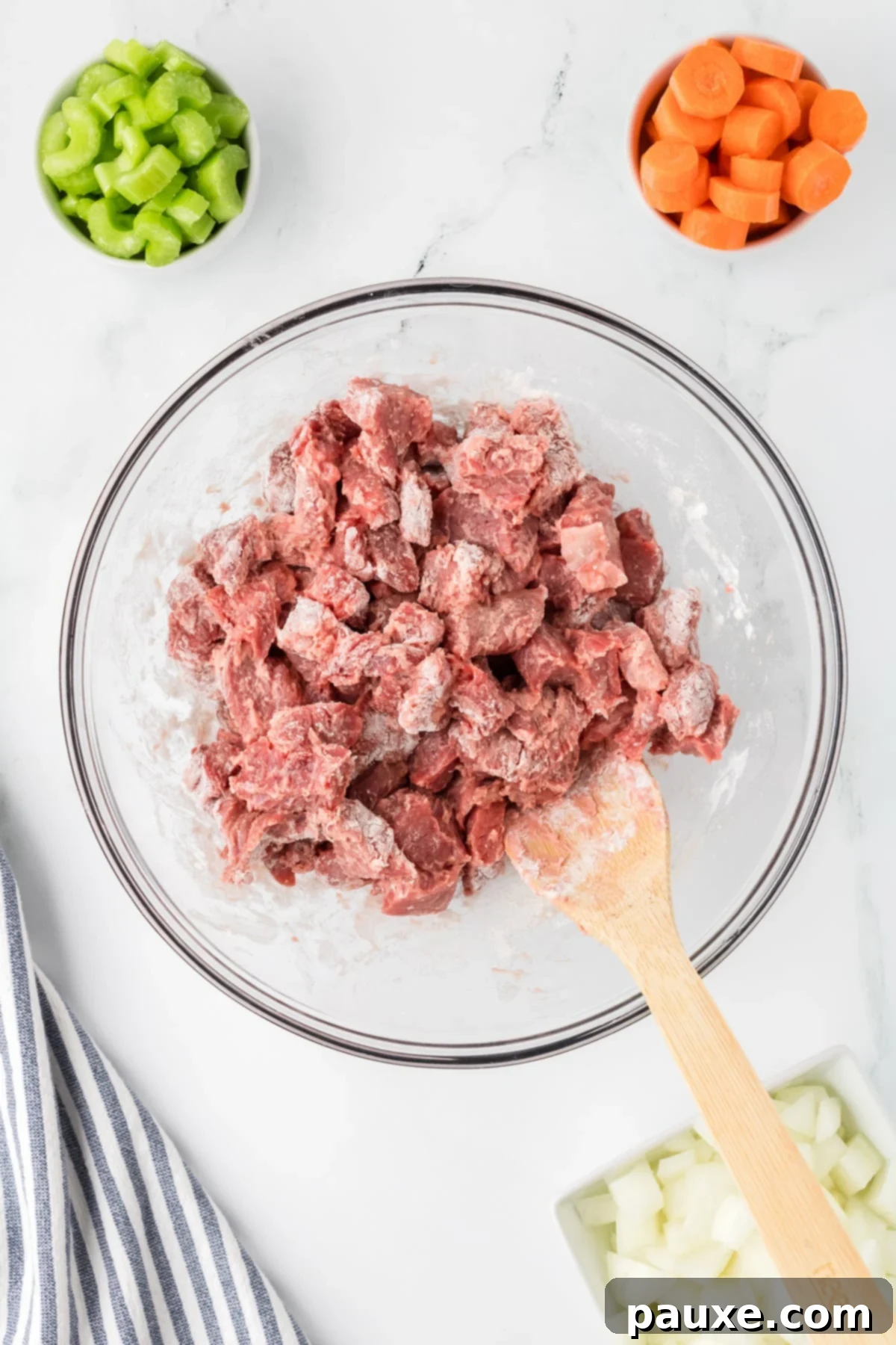 Comforting Slow Cooker Beef Stew and Dumplings 4 Beef stew meat being coated evenly with all-purpose flour in a large bowl.
