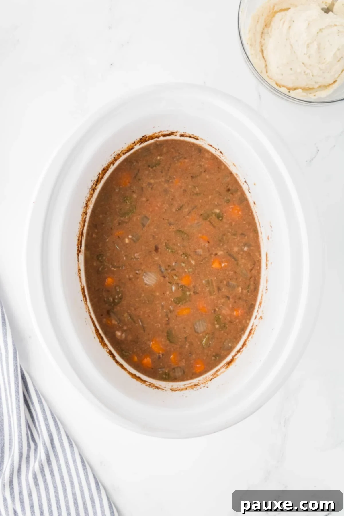 Comforting Slow Cooker Beef Stew and Dumplings 9 A slow cooker filled with fully cooked beef stew, ready for dumplings to be added.