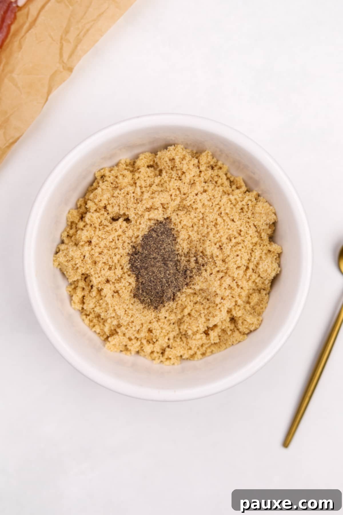 Crispy Caramelized Bacon 4 A small bowl of brown sugar with black pepper added to it.