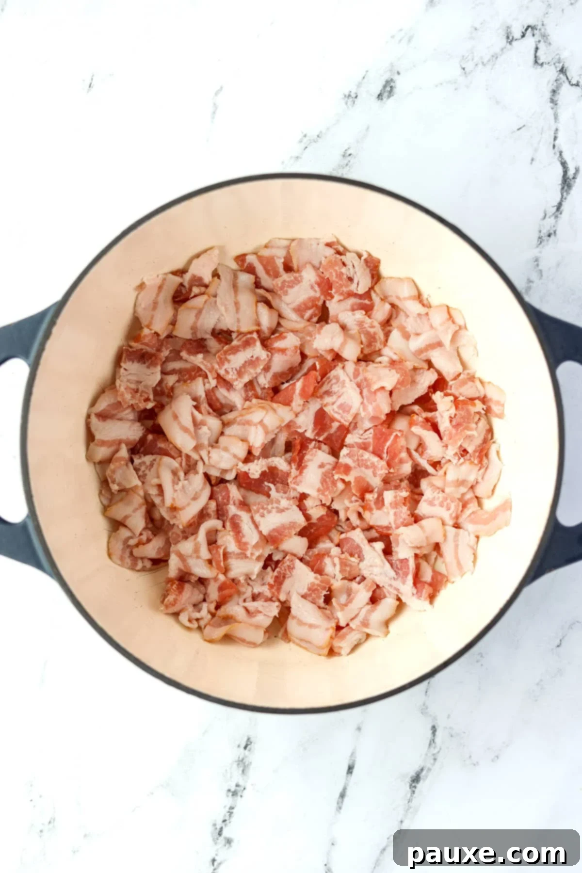Crafting Crispy Homemade Bacon Bits 6 A robust Dutch oven on a stovetop, partially filled with small, raw diced bacon pieces beginning to cook, indicating the start of the rendering process.