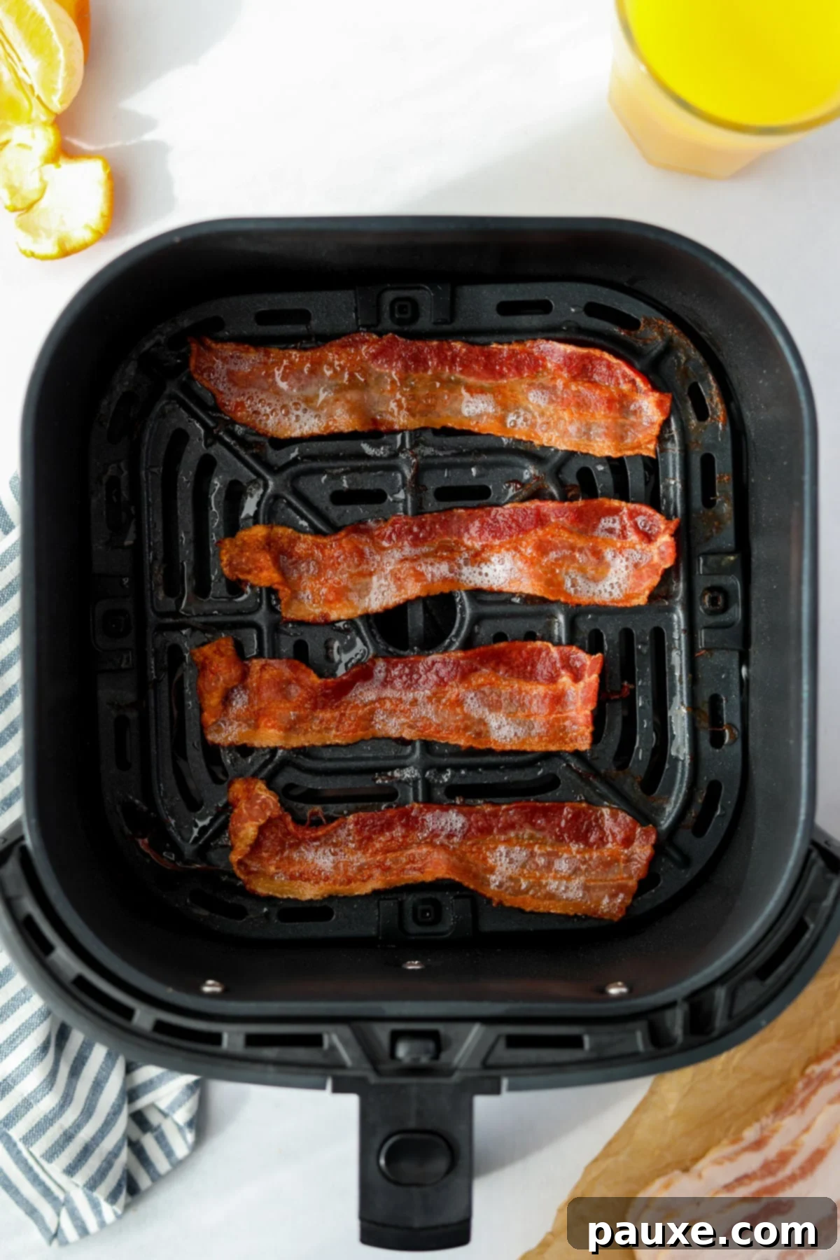 Crispy Air Fryer Bacon 5 Crispy, perfectly cooked bacon slices in an air fryer basket after cooking.