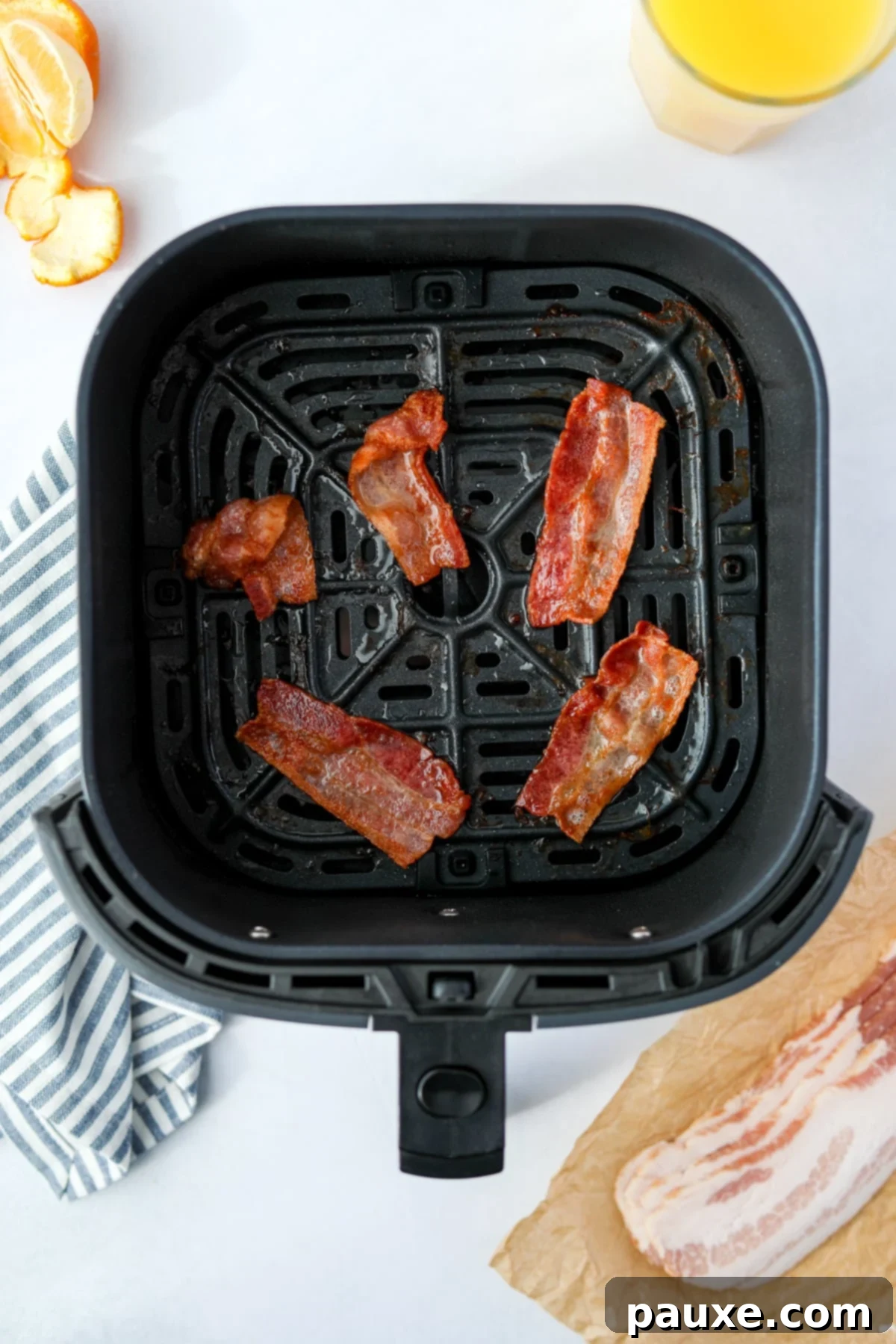 Crispy Air Fryer Bacon 7 Crispy half slices of cooked bacon presented in an air fryer basket.