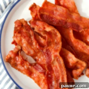 Crispy Air Fryer Bacon 10 Slices of crispy air fryer bacon on a white plate, ready for serving.