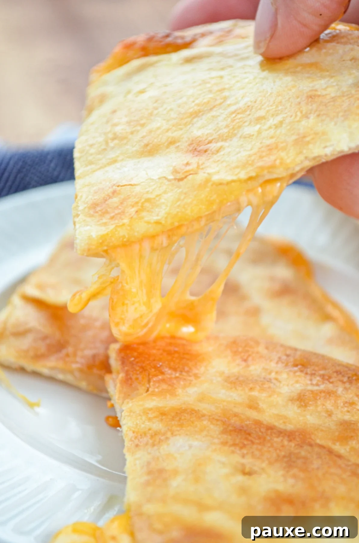 A stack of golden cheese quesadillas with a cheesy stretch.