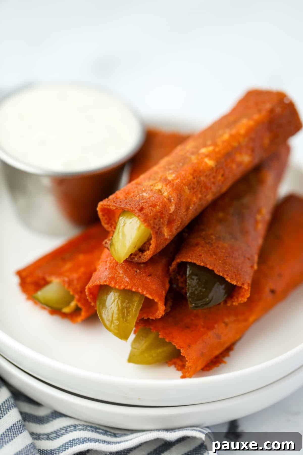 Zesty Brined Cheese Bites 2 A stack of golden-brown cheesy pickles ready to be enjoyed with ranch dressing in the background.
