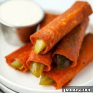 Zesty Brined Cheese Bites 10 A stack of cheesy fried pickles with a small container of ranch dressing in the background, showcasing their crispy texture and appeal.