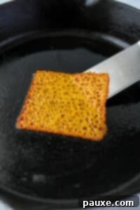 Zesty Brined Cheese Bites 12 Using a spatula to loosen a melted cheese slice from a hot skillet, preventing it from sticking.