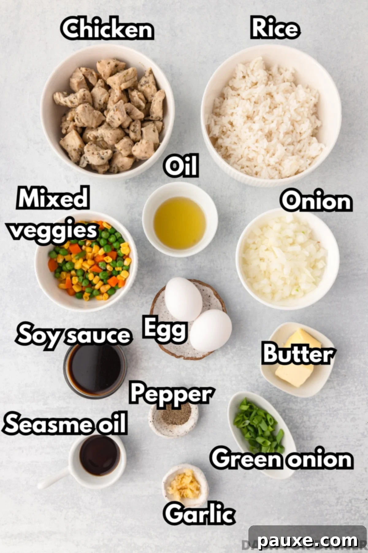 The Art of Benihana Chicken Fried Rice 3 A collection of ingredients neatly arranged for making chicken fried rice, including bowls of cooked rice, diced chicken, eggs, butter, and mixed vegetables.