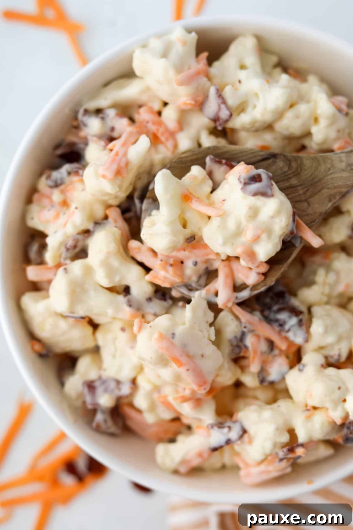 Spiced Cauliflower Salad with Tahini 2 A wooden spoon scooping some cauliflower salad from a bowl.