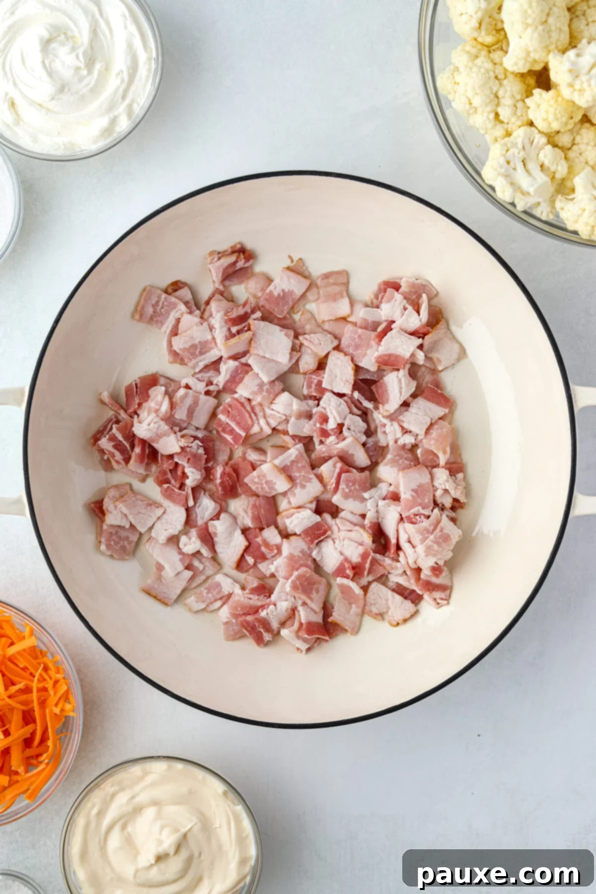 Spiced Cauliflower Salad with Tahini 4 A skillet with raw bacon pieces in the center.