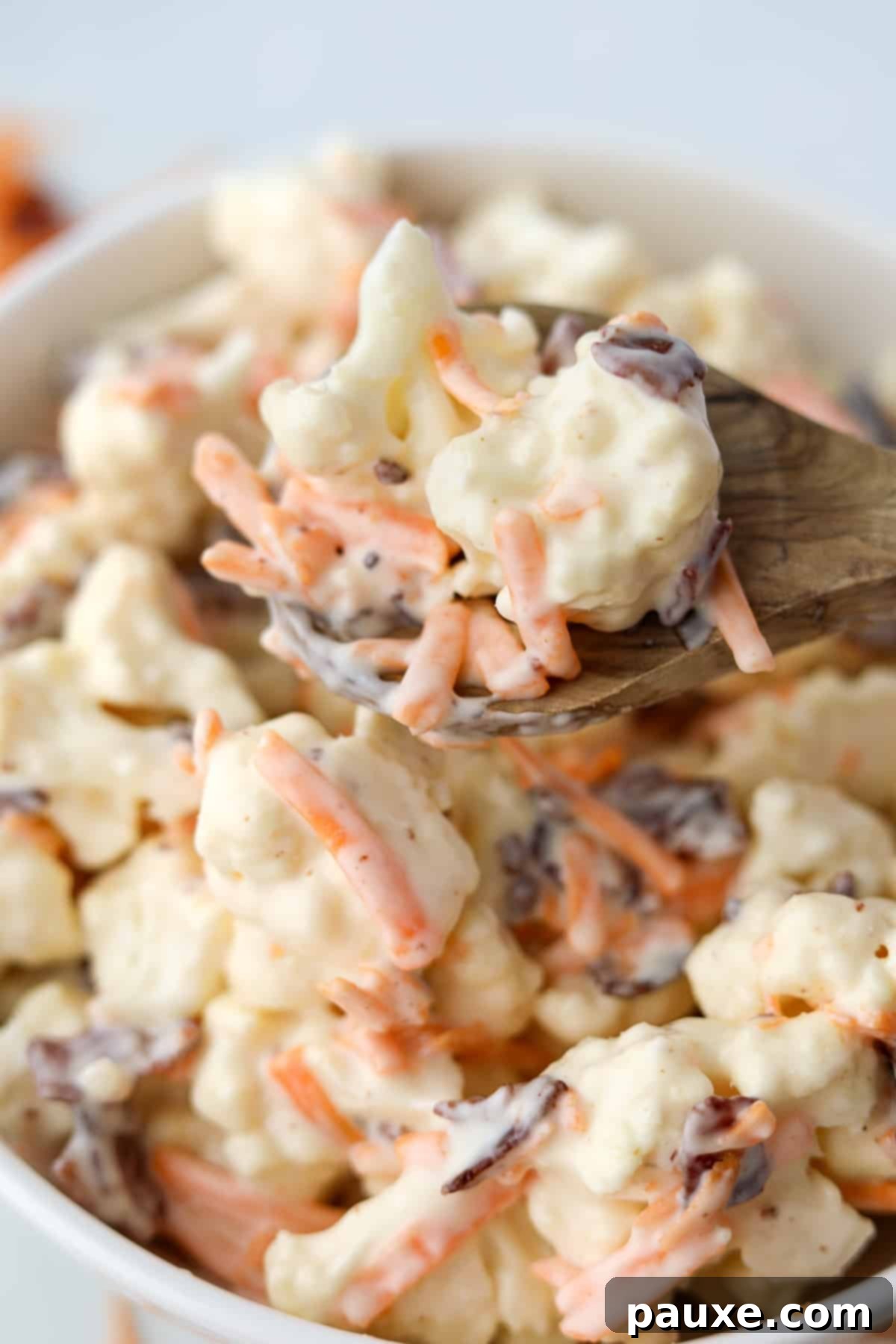 Spiced Cauliflower Salad with Tahini 8 A wooden spoon lifting cauliflower salad from a bowl.