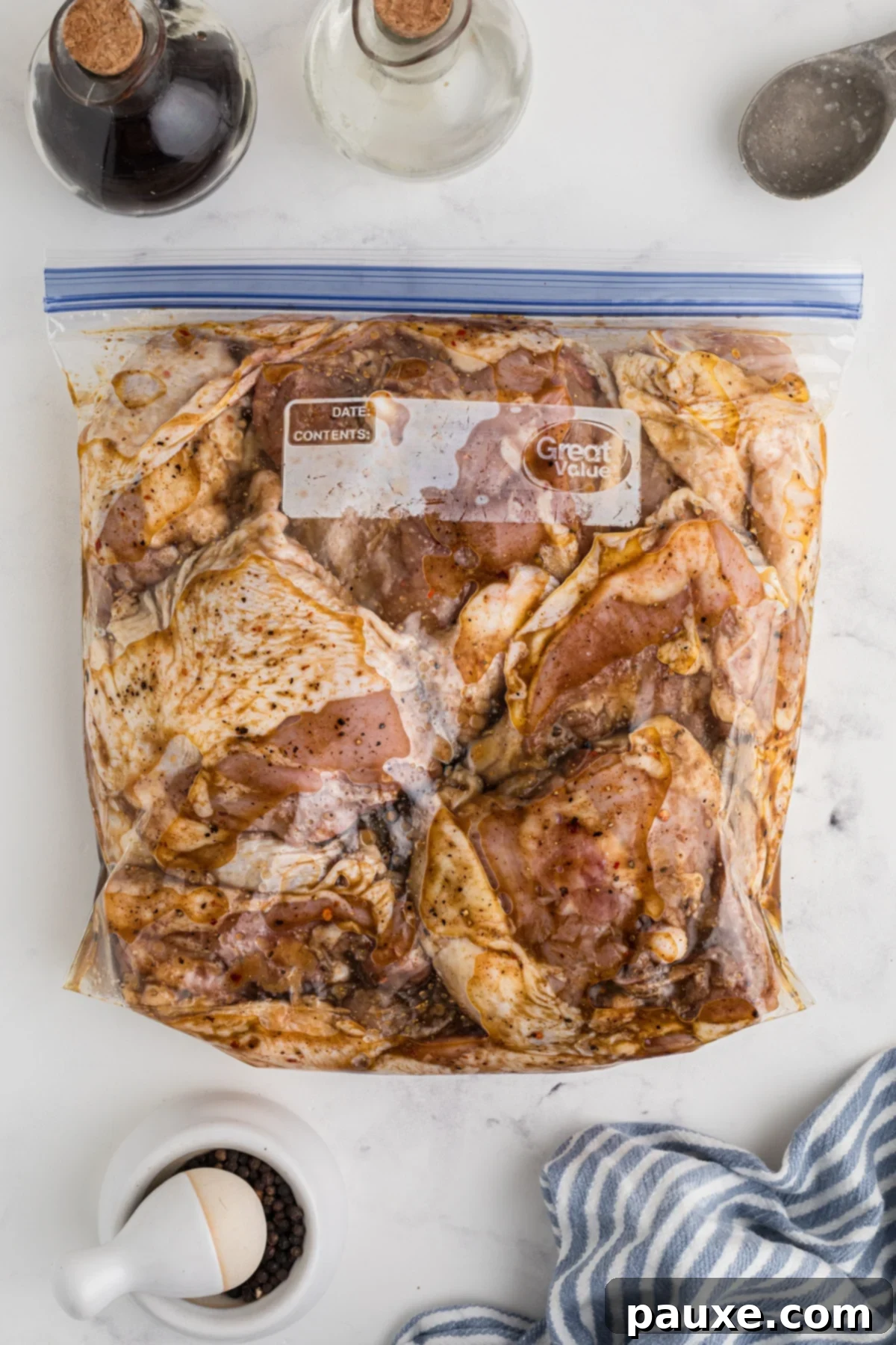 Golden Baked Chicken Thighs 6 Raw chicken thighs being added to a freezer bag containing the prepared marinade.