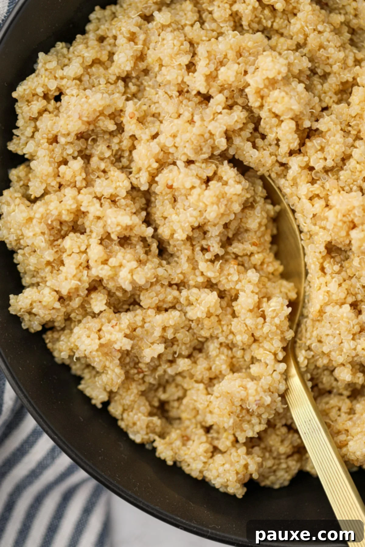 Effortless Instant Pot Quinoa 2 Scooping fluffy quinoa from a black serving bowl with a spoon.
