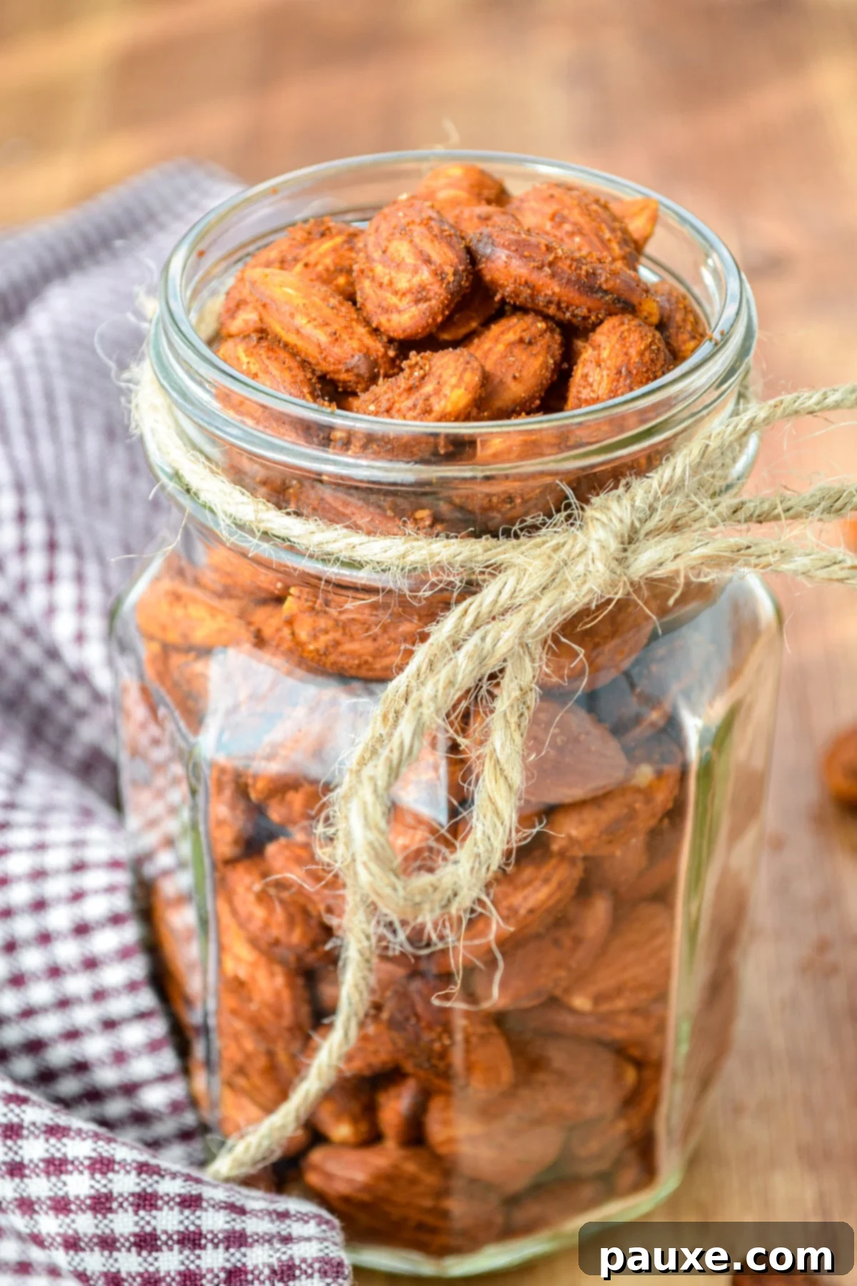 Crispy Golden Air Fryer Almonds 7 A fancy glass jar of roasted almonds, with a piece of twine tied around it.