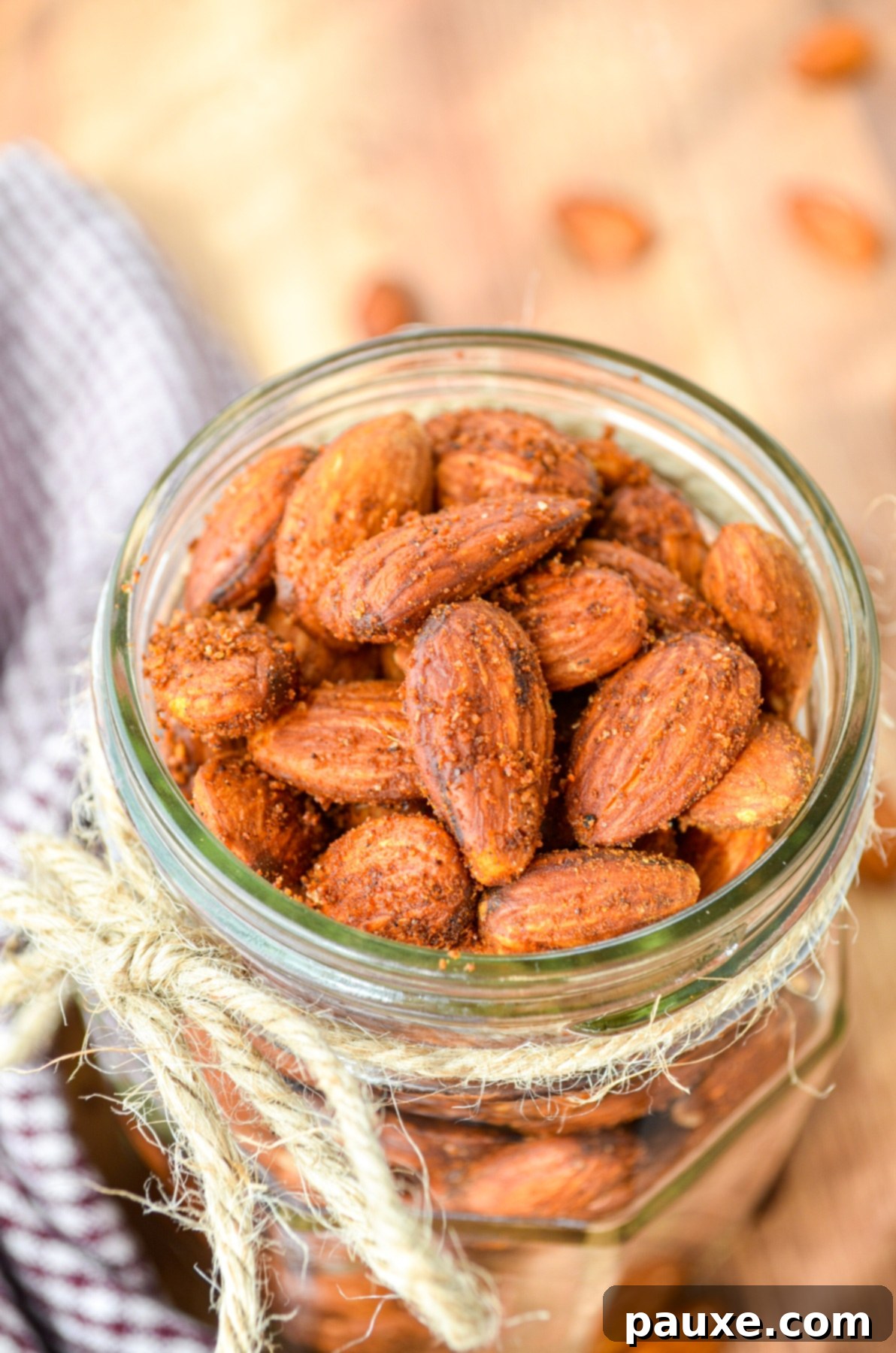 Crispy Golden Air Fryer Almonds 8 A jar full of roasted almonds, with a piece of twine tied around the rim.