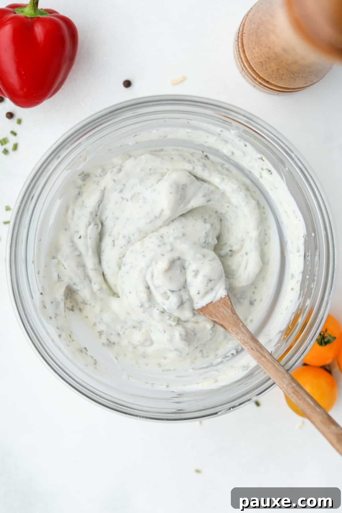 Healthy Greek Yogurt Ranch 6 A bowl of homemade salad dressing that's being stirred with a wooden spoon.