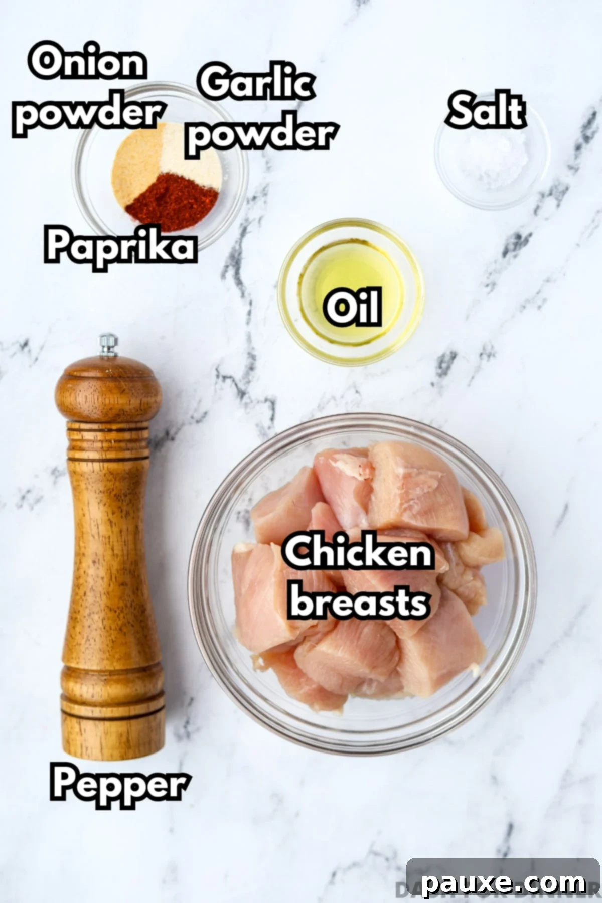 Golden Air Fryer Chicken Poppers 3 An overhead view of a bowl of chicken pieces, seasonings, oil, salt, and pepper.