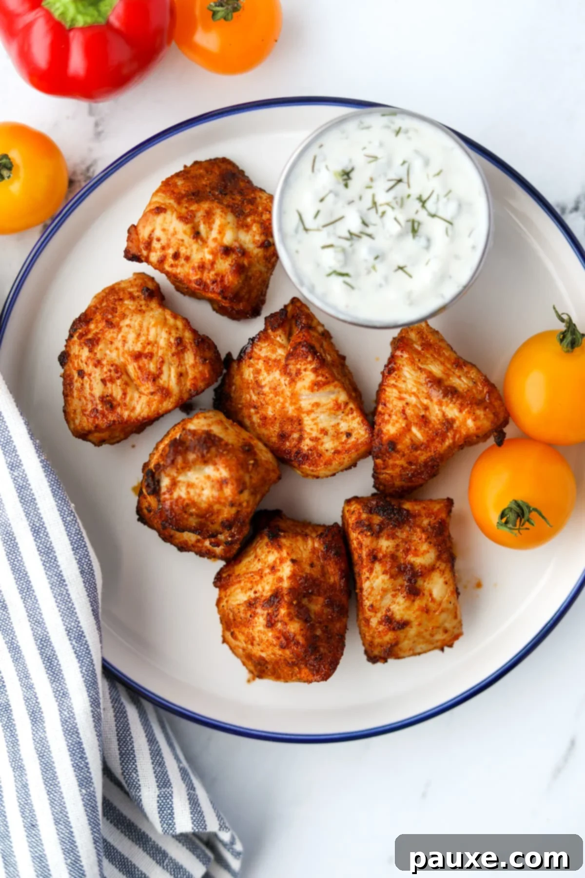 Golden Air Fryer Chicken Poppers 5 A plate with unbreaded chicken nuggets and a side serving of ranch dressing.