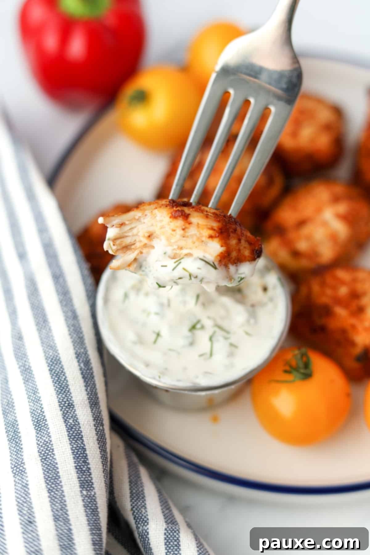 Golden Air Fryer Chicken Poppers 8 A fork dipping a small piece of chicken into ranch dressing.