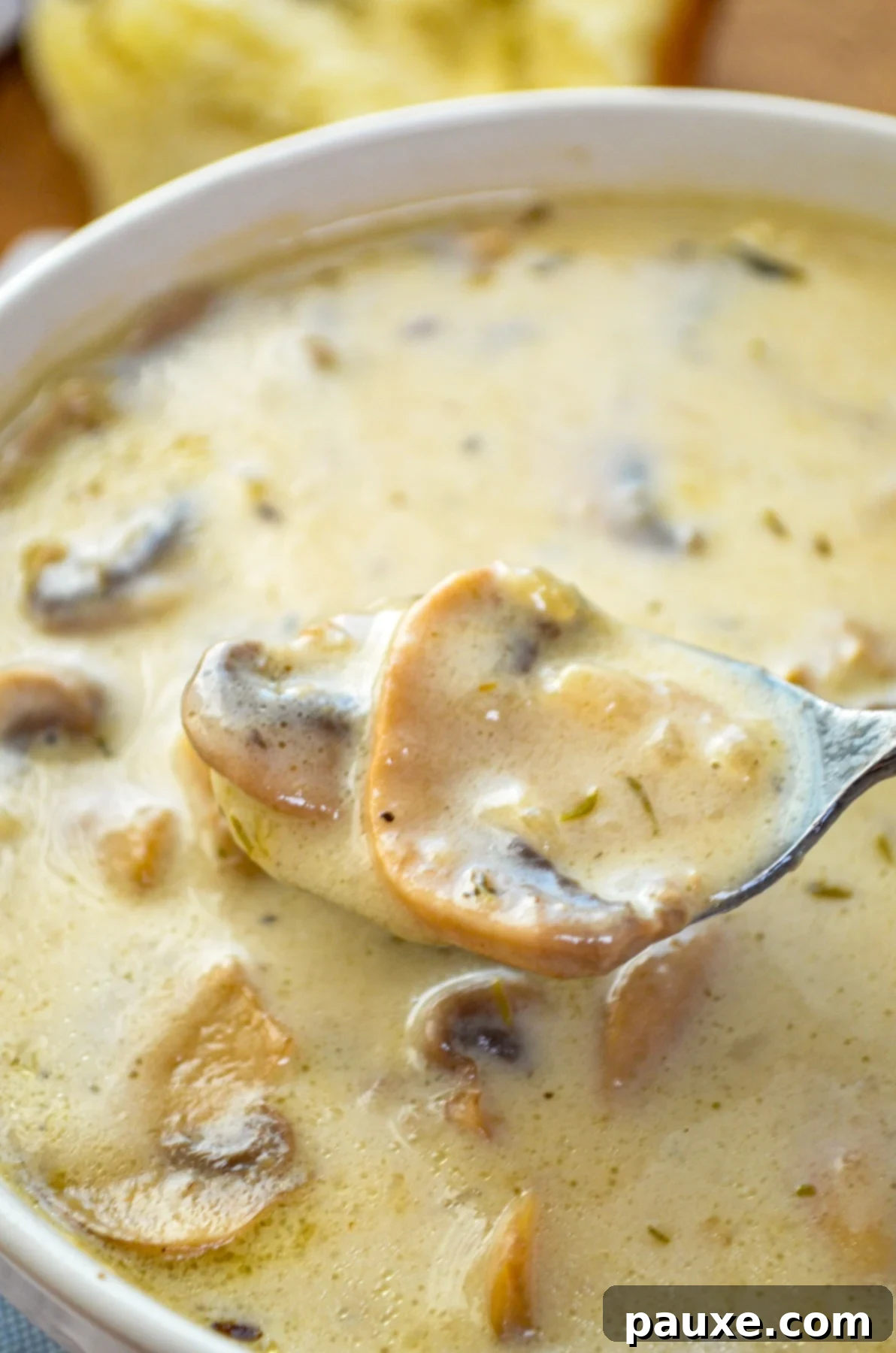 Instant Pot Creamy Mushroom Comfort 2 A bowl of mushroom soup with a spoon taking a spoonful.
