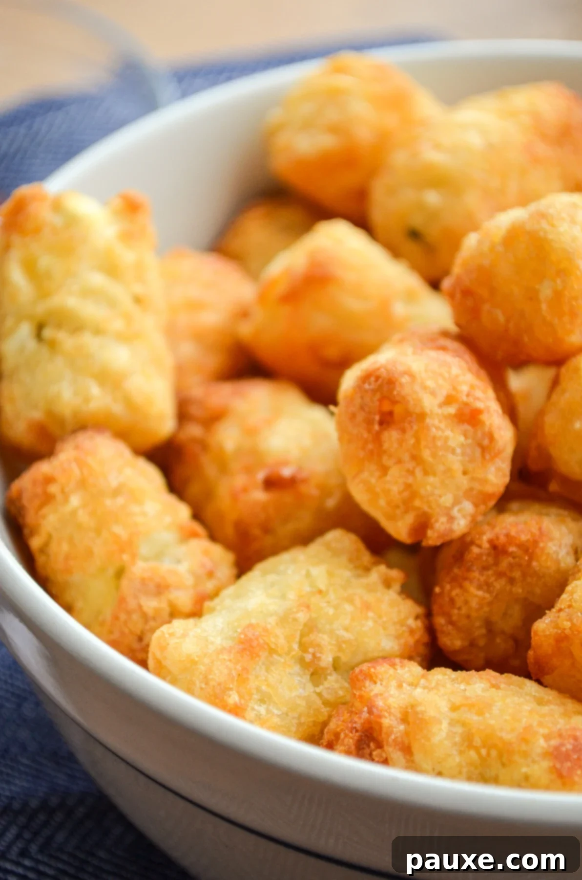 Crispy Air-Fried Tater Tots 7 A large bowl filled with perfectly golden and crispy air-fried tater tots, glistening and ready to eat.