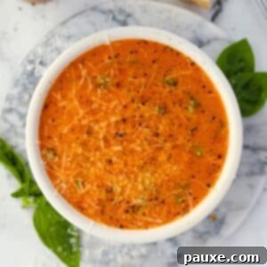 Sweet & Smoky Tomato Bisque 8 A bowl of cherry tomato soup garnished with parmesan cheese, basil, and cracked black pepper.