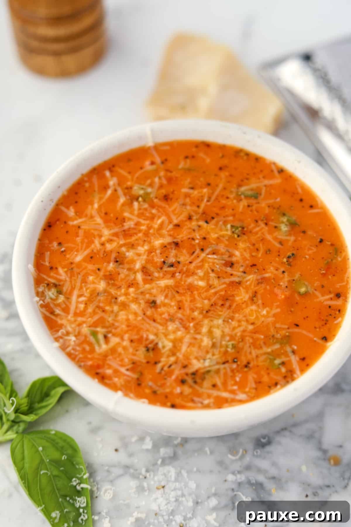 Sweet & Smoky Tomato Bisque 7 A pristine white bowl showcasing a perfectly smooth and creamy serving of roasted cherry tomato soup, ready to be enjoyed.