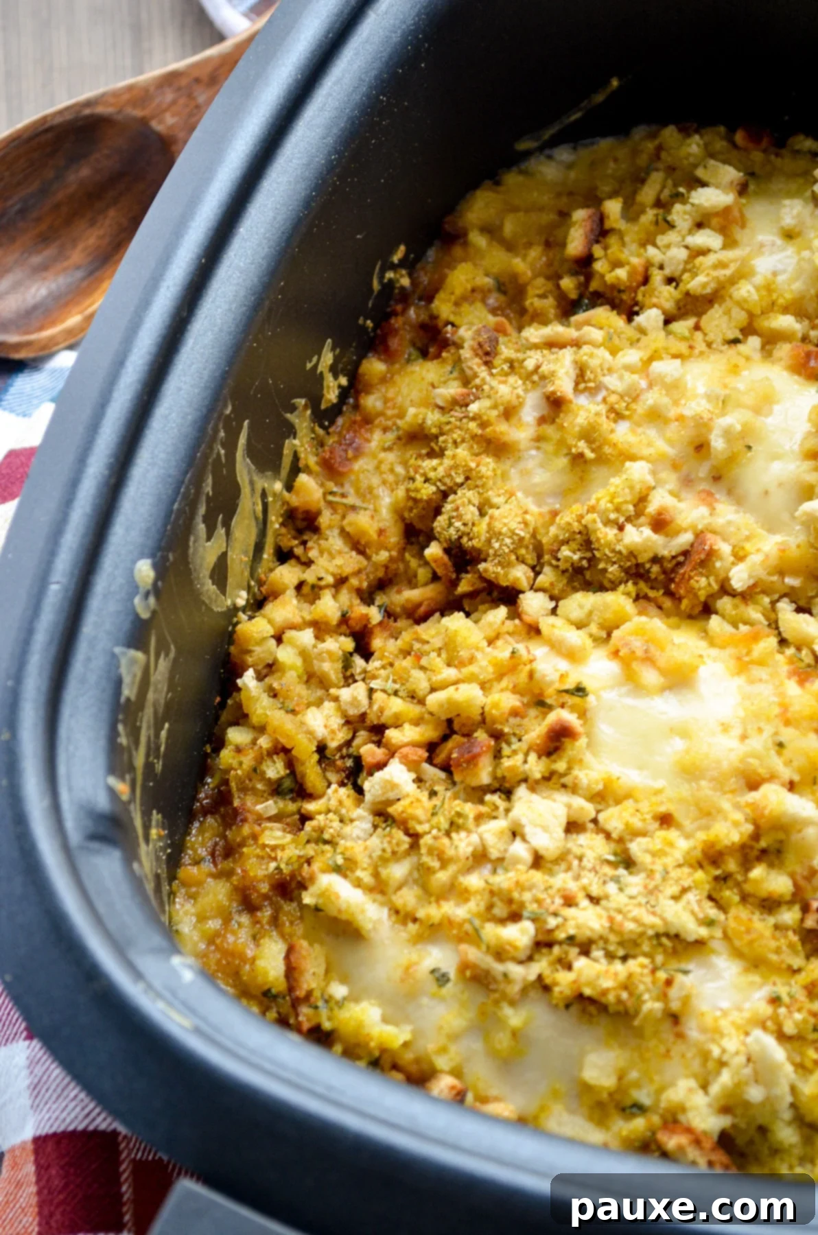 Creamy Swiss Chicken Slow Cooker Comfort 8 A slow cooker filled with golden brown stuffing and swiss cheese covered chicken breasts, ready to serve.